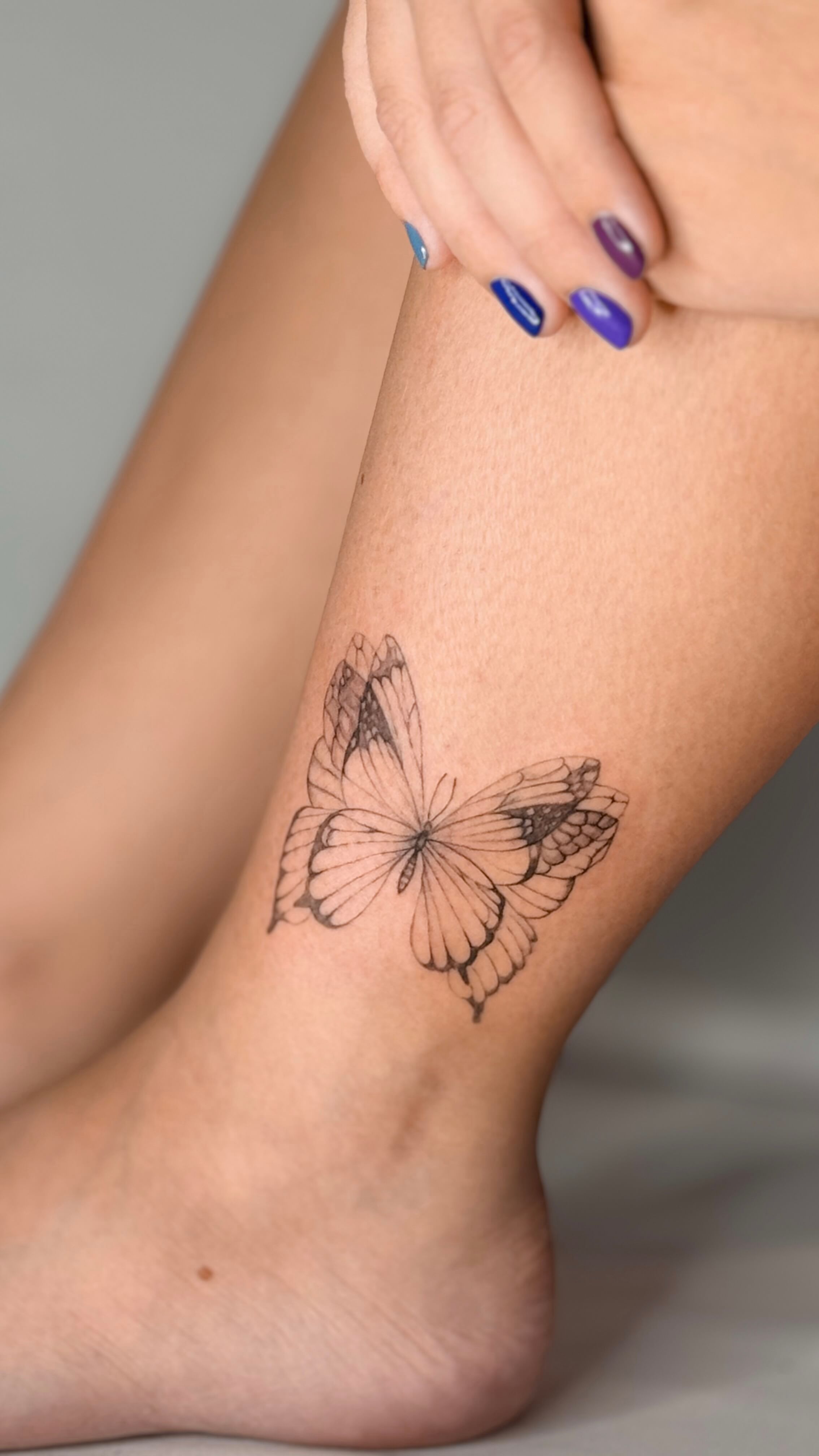 Fine line butterfly tattoo on the ankle
