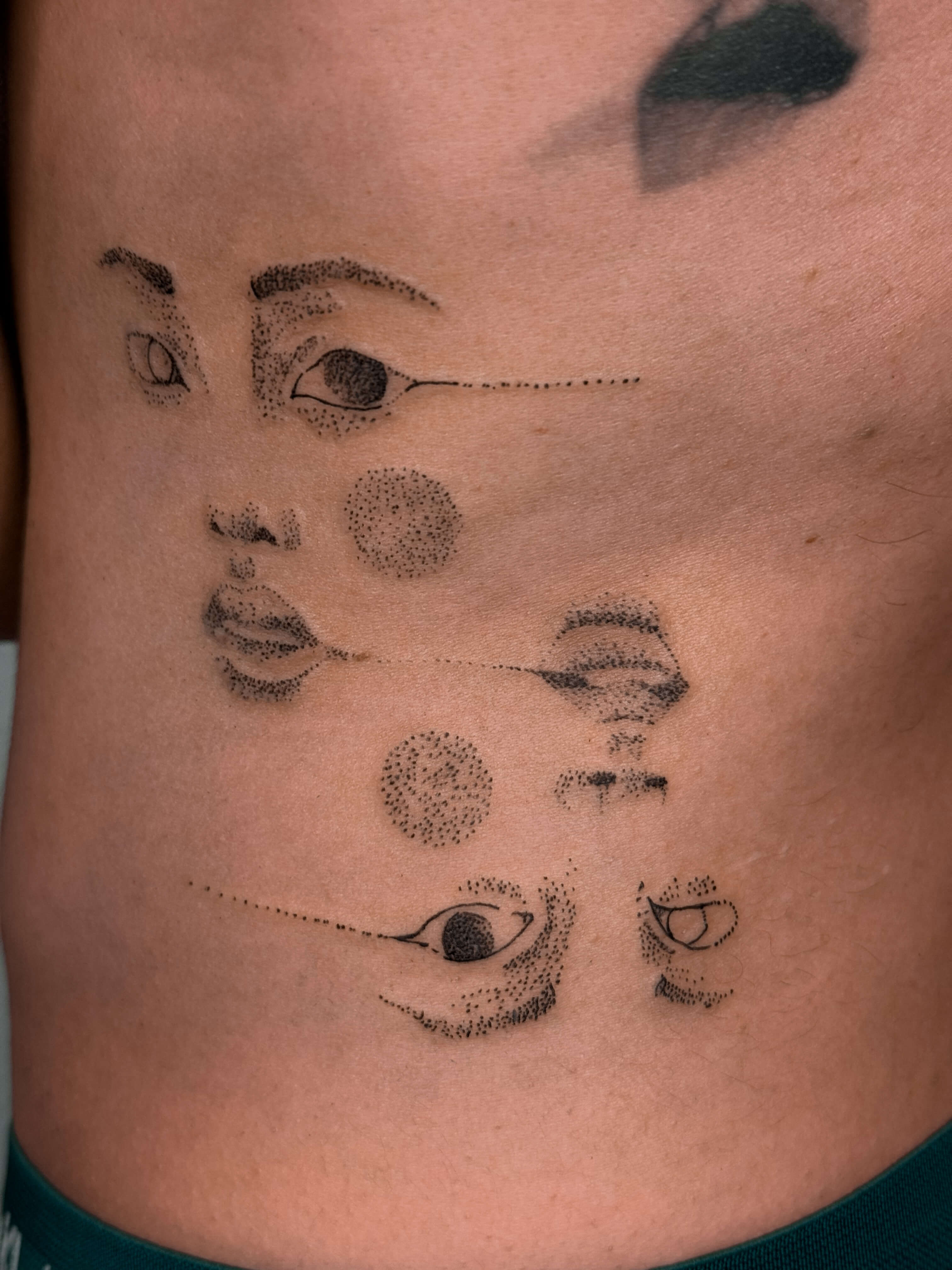 Fine line faces tattoo on the lower back