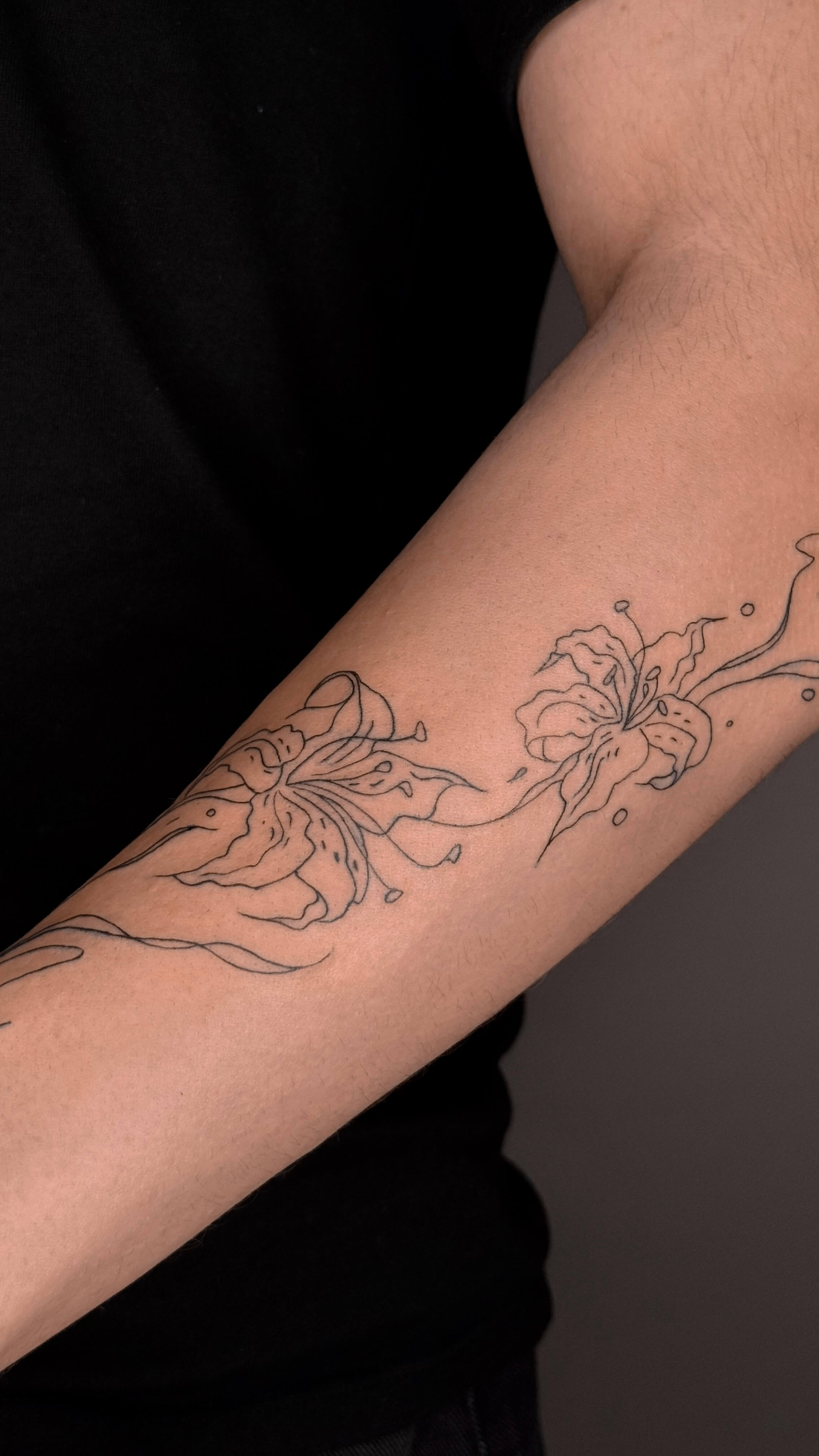 Fine line lilies tattoo on the arm