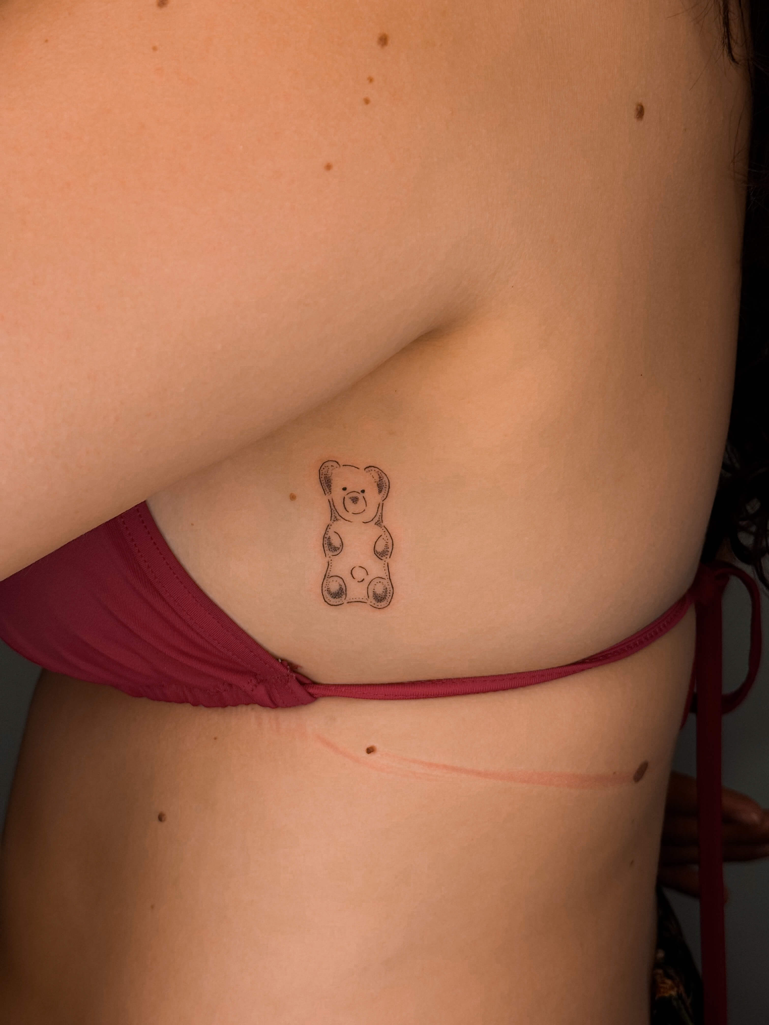 Fine line gummy bear tattoo