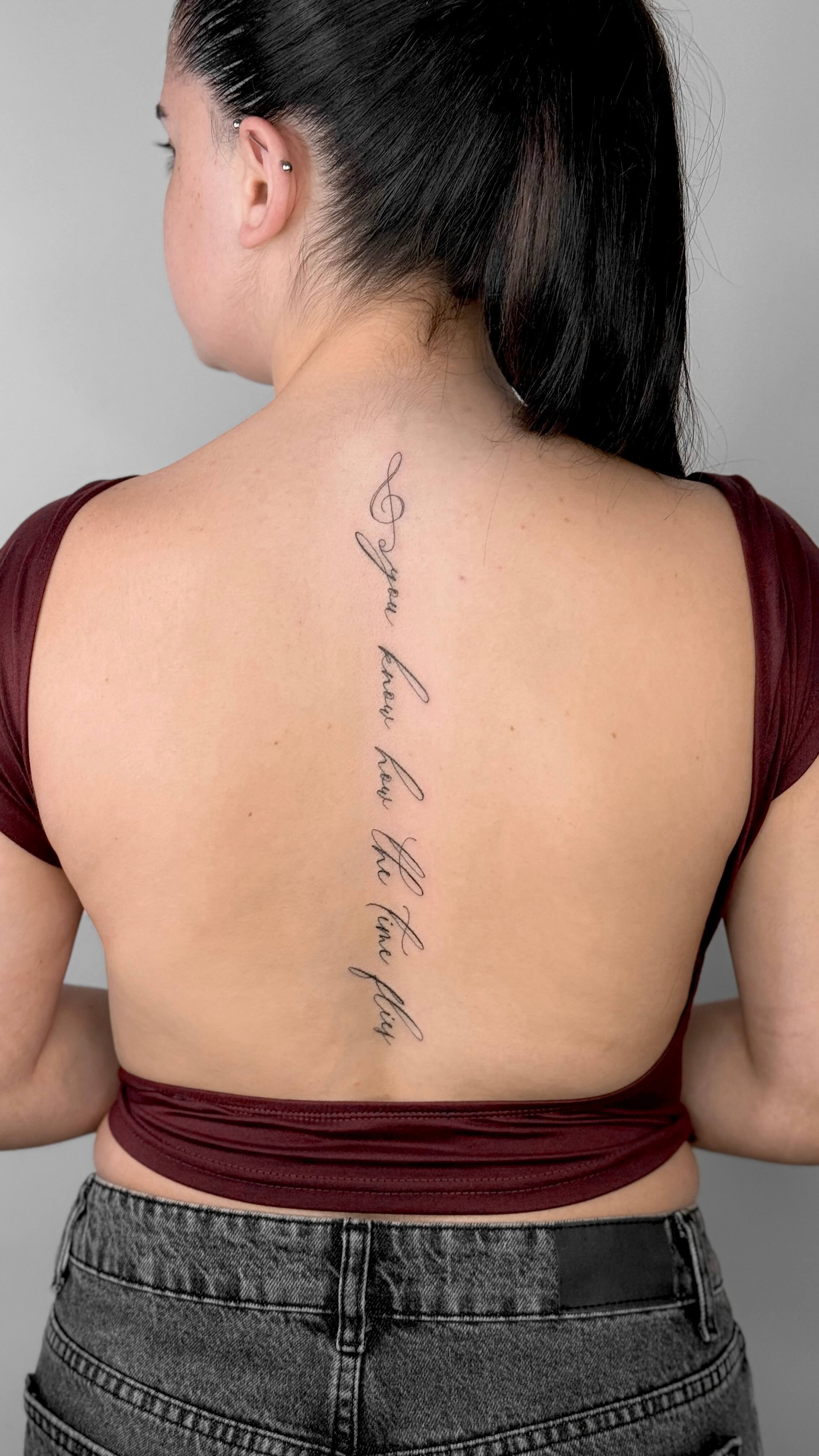 Lettering tattoo along the spine