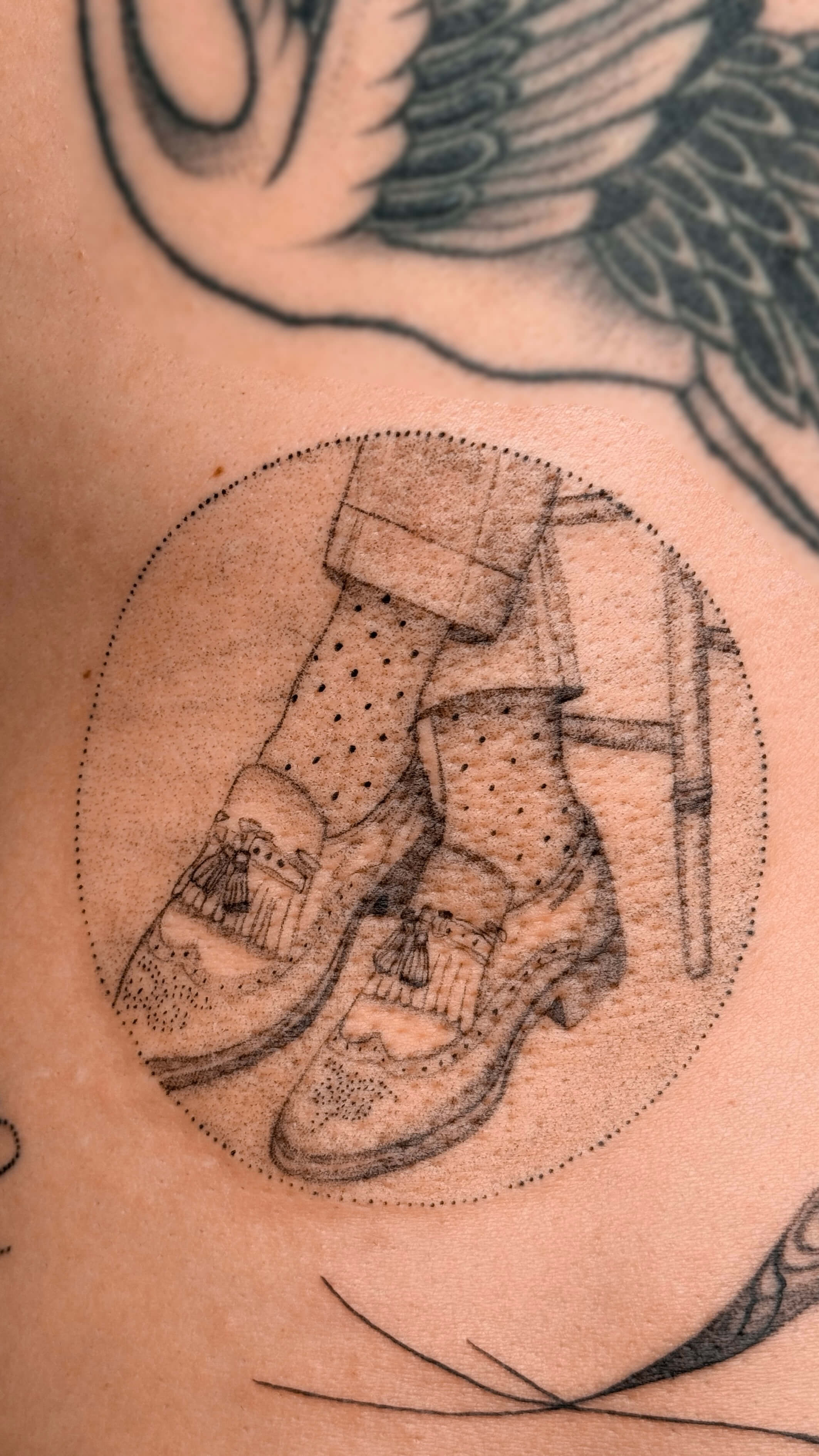 Micro-realism boots tattoo on the lower back