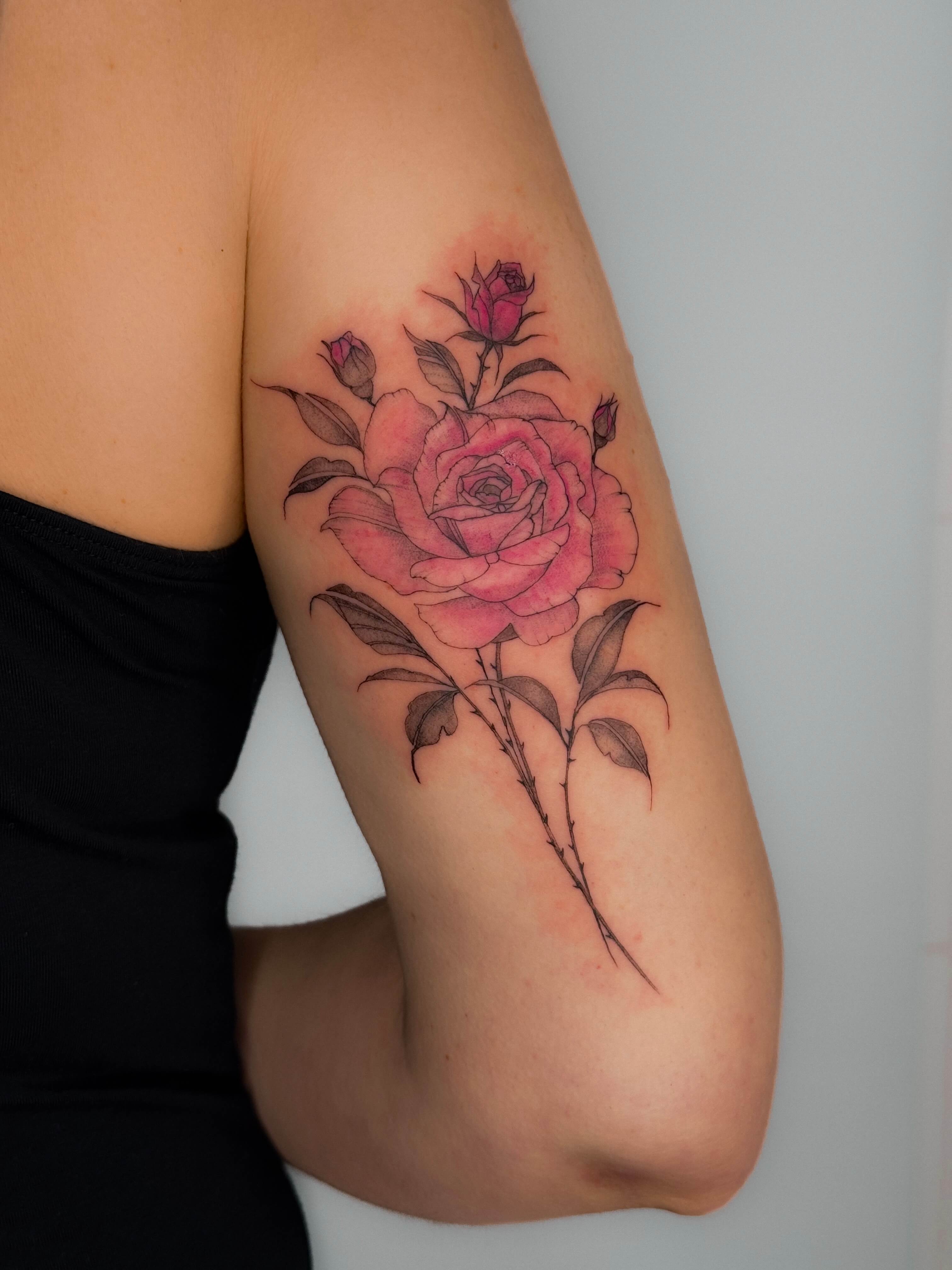 Fine line rose tattoo with color on the arm